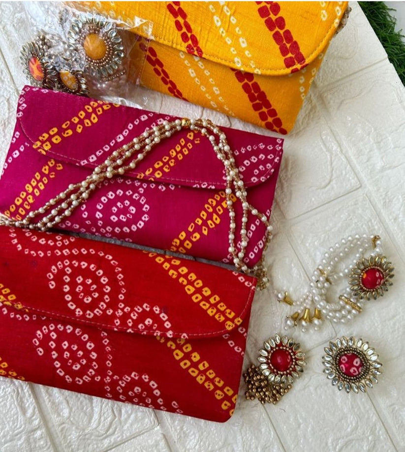 Bandhani print potli clutch with pearl chain paired with matching kundan jewelry set for wedding and festive wear