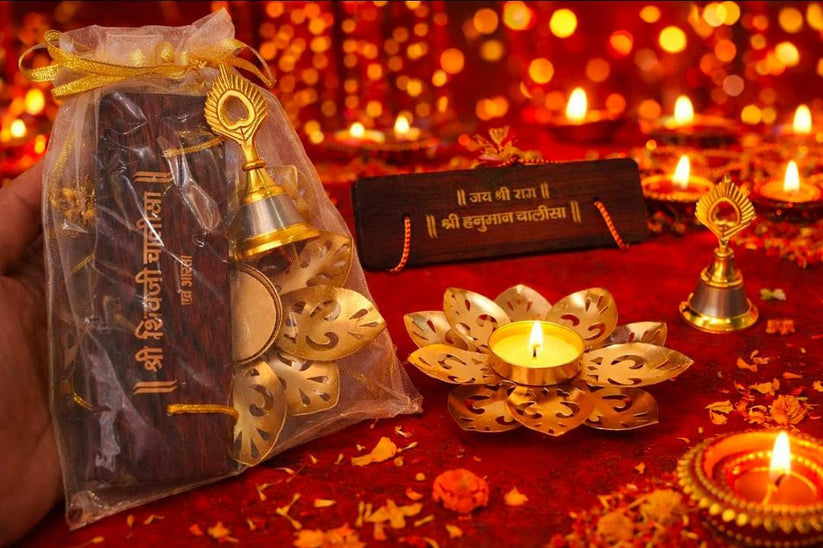 Diwali gift potli set with Hanuman Chalisa, brass bell and lotus tea light holder for pooja and festive gifting